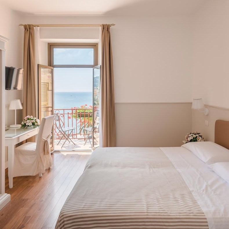 Camera: finiture chiare e balcone vista mare